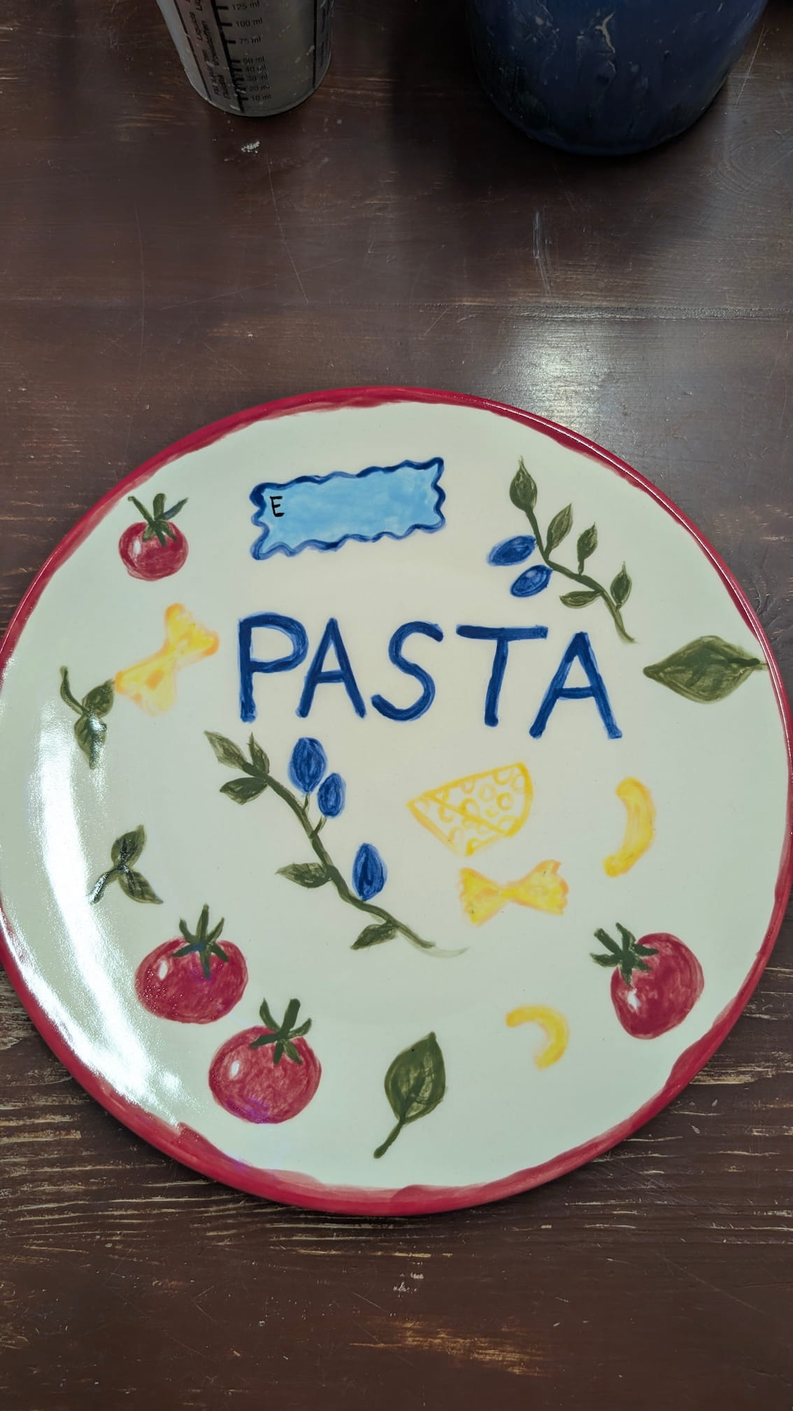 Talerz na makaron z napisem PASTA oraz malowanymi motywami włoskimi: pomidory, bazylia, ser i kluski.